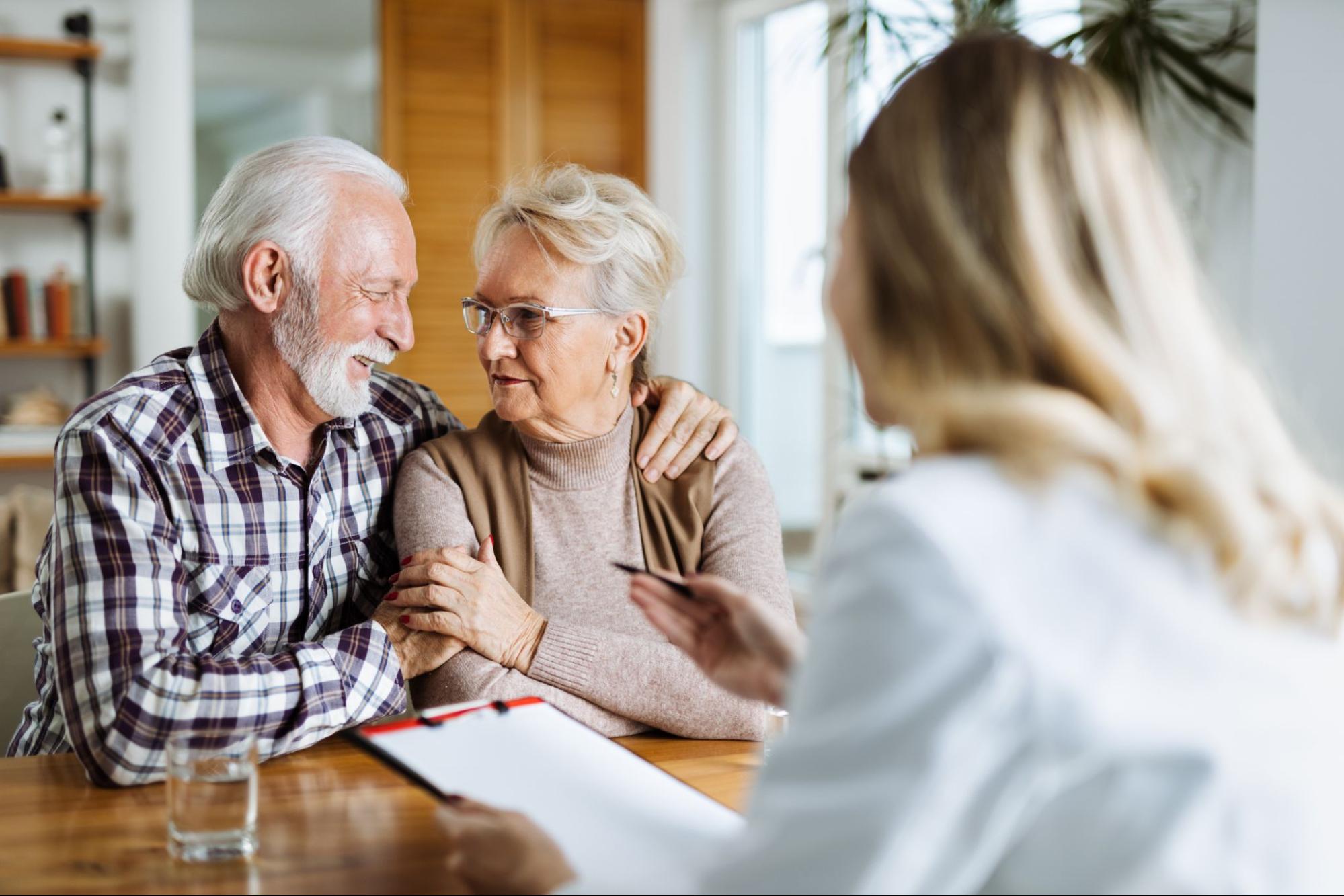 Aging life care manager reviewing a care plan with an older couple at home.